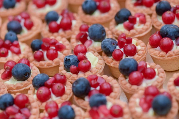 Mini koláče s vanilkovým krémem, borůvky a červený rybíz — Stock fotografie