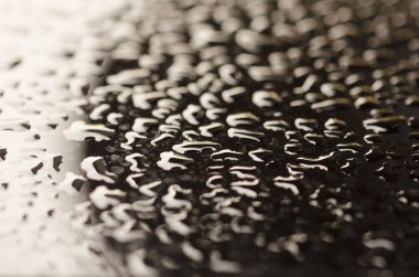 siyah bir yüzey üzerinde su damlaları