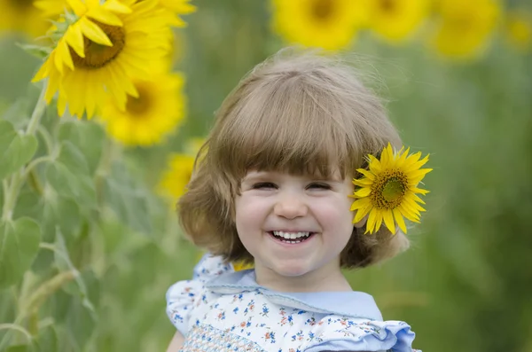 Маленькая девочка на подсолнечном поле — стоковое фото