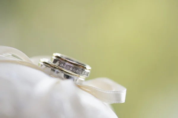 Wedding rings against light green background — Stock Photo, Image