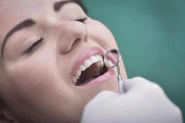 Молодая женщина и стоматологический инструмент — стоковое фото