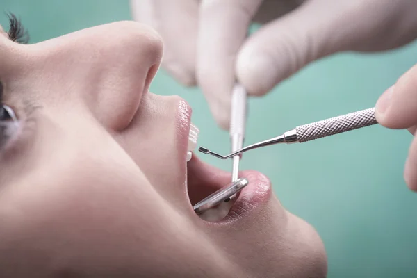 Mulher jovem e instrumento dentário — Fotografia de Stock