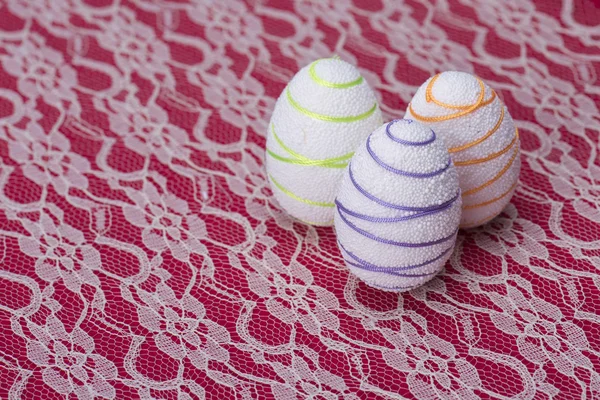 White Easter eggs against a red and white lacy — Stock Photo, Image