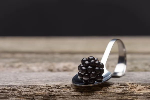 Einzelne Brombeere auf einem kleinen Löffel — Stockfoto