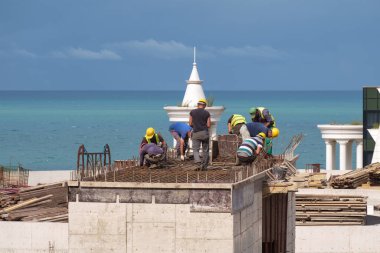 Batumi, Gürcistan, 22 Eylül 2020: İnşaat alanının tepesinde çalışan inşaat işçisi, mavi deniz ve gökyüzü arka planı