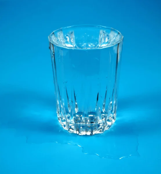 Drinken Van Schoon Water Een Glas Een Blauwe Achtergrond — Stockfoto