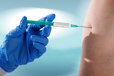 Doktor hastasının omzunda aşı yapmak için hastayı kapatın. Covid-19 Aşılama