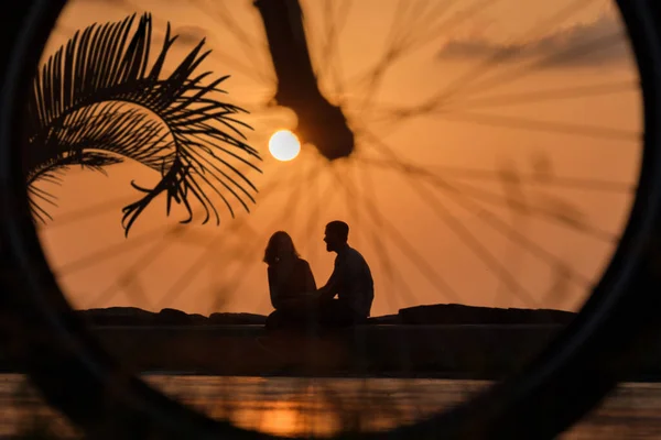 Siluetas Pareja Relajándose Parque Junto Mar Atardecer Ver Través Rueda —  Fotos de Stock