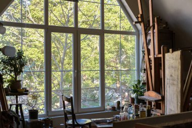 Güneş ışığı, dışarıdaki doğa arka planıyla birlikte mahsul iç mekanının büyük penceresinden içeri bakıyor.