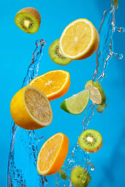 Falling fresh mixed fruits. Slices of the lemon, orange and lime with fresh water in the air. Flying fruits concept