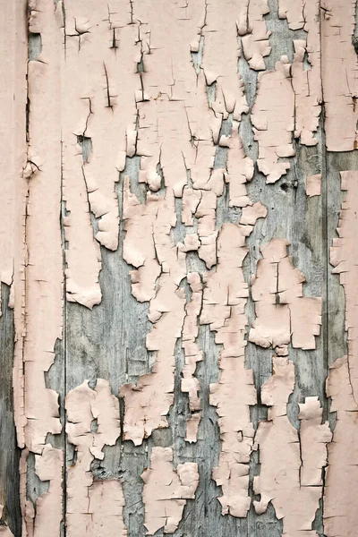 Peeling pink paint on the old rough wooden surface, peeling paint texture