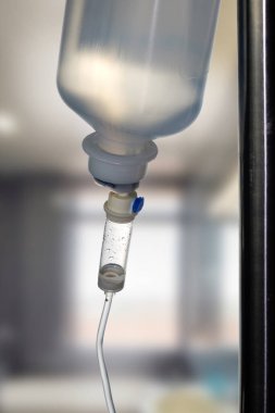 Hastanedeki hastalar için serum solüsyonlu serum serumu serumunun kapanışı, bulanık oda arka planlı seçici odak