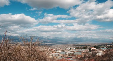 Kafkas dağlarının güzel manzarası ve kasabadan bulutlu gökyüzü 