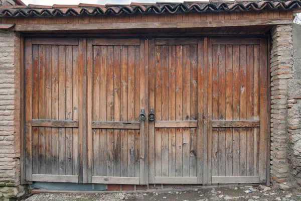 大きな丸金属製のハンドルを持つ古い木製の門 — ストック写真