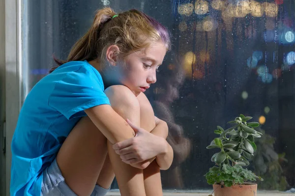 Ένα Θλιμμένο Κορίτσι Μπλε Πουκάμισο Κάθεται Στο Περβάζι Του Παραθύρου — Φωτογραφία Αρχείου