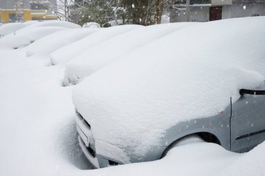 Şiddetli bir kış fırtınasından sonra birçok park edilmiş araba tamamen derin karla kaplandı..