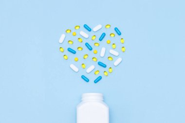 Kalp şeklinde farklı tabletler ve kapsüller. Sağlıklı yaşam konsepti, takviyeler, vitaminler.