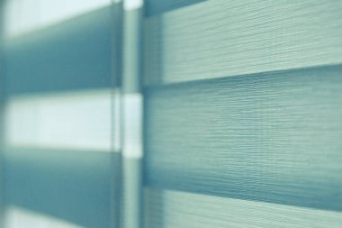 Penceredeki renkli kumaş jaluzileri kapatın. Perdeleri açın..