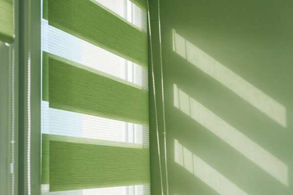 Закрыть цветные рольставни ткани на окне. Занавески.