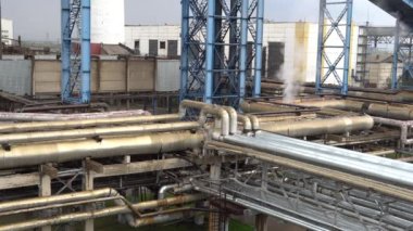 Büyük bir fabrikanın bölgesi. Yağmurda fabrikada büyük, endüstriyel borular.