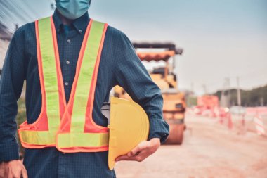 Close up hand holding helmet hard hat Engineering concept, Worker Engineer Standing on road site construction