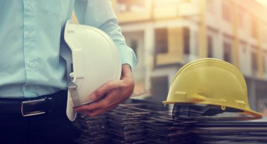 Engineering hold safety hard hat work building construction,Project Engineer holding helmet building estate background