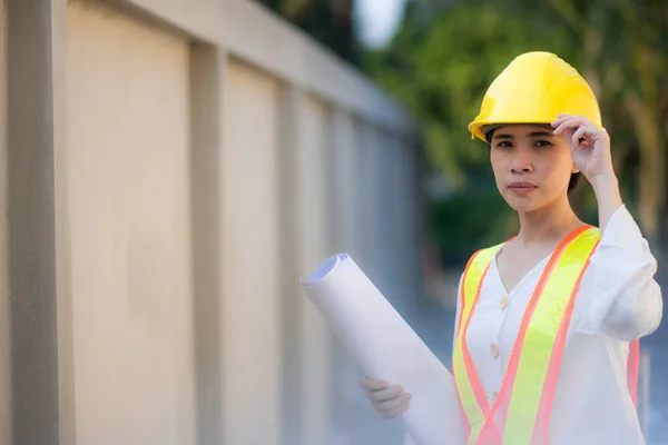Asian women worker Engineer holding blueprint on site construction