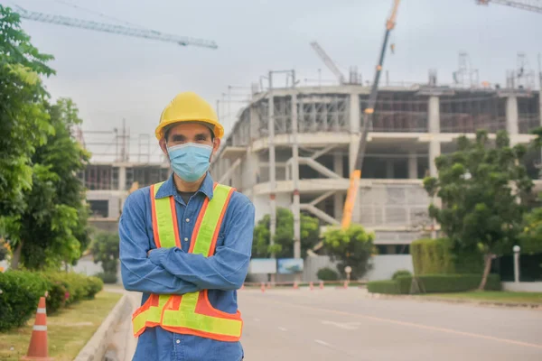 Asian man engineer face mask standing at site construction worker professional ,Face mask protect coronavirus covid 19 and PM2.5