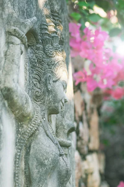 摘要泰国古代女性石材装饰背景在粉红色花朵背景下被太阳光照射 场深度浅的图像 — 图库照片