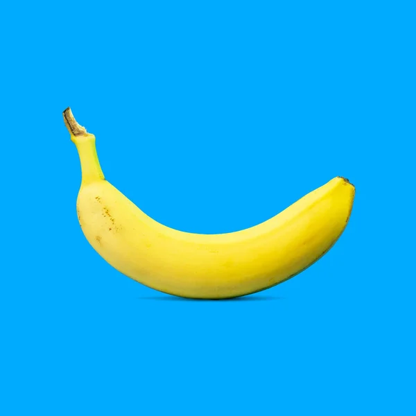 最小限の夏の食品コンセプト コピースペースと青鮮やかな背景に黄色のバナナフルーツ鋳造影 ストック写真