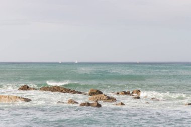 Su sıçratan dalgalar ve kayalarla dramatik deniz manzarası. Sahilde kayalar ve güzel dalgalar. Rocky sahil şeridi. Cliff 'le deniz kenarında. Seyahat yerleri. Seyahat ve tatil kavramı.