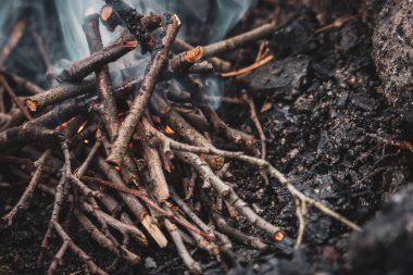 Şöminede yanan odun. Tahta çubuklar ve ateş topları. Ateş ve duman. Piknik konsepti. Çevre tehlikesi. Şenlik ateşi yakın. Ormanda Tatil. 