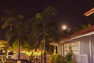 Geceleri boş bir otel. Sıcak terası olan tropik bir tatil köyü. Samimi bahçesi ve balkonu olan bir villa. Palmiye ağaçları ve mobilyaları olan boş lüks bir kulübe. Büyük teraslı bir ev..