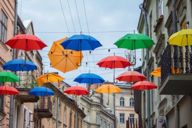 Lviv, Ukraine - 06/14/2021: colorful umbrellas in the streets. Art object in old city of Lviv. Pedestrian street with bright decoration. Variety of multicolored umbrellas. Lviv cityscape. 