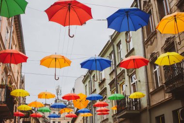 Lviv, Ukraine - 06/14/2021: colorful umbrellas in the streets. Art object in old city of Lviv. Pedestrian street with bright decoration. Variety of multicolored umbrellas. Lviv cityscape. 