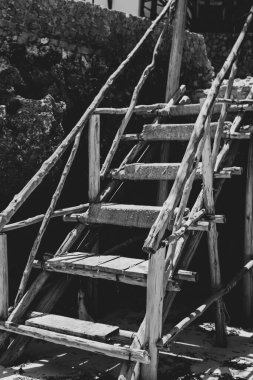 Kumsaldaki eski ahşap merdiven. Tek renk olsun. Tropikal plajda taşlı taşlı merdiven, siyah ve beyaz. Kayadaki antik merdivenler. Tropikal köyde mimari ayrıntıları.