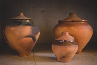 Eski kil kaplar. Çömlek konsepti. Seramik terracotta vazosu. Kapaklı yaratıcı porselen kaseler. Toprak kabı konsepti. El yapımı çaydanlık. Kahverengi tencere. Mutfak dekorasyonu. Eski el işi kavanozu. 