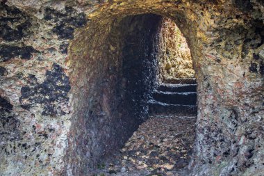 Kayadaki doğal mağara. Sahildeki deniz mağarası. Tropikal doğa. Merdivenleri ve dar girişi olan mağara. Vahşi Afrika 'da seyahat etmek. Kıyı dağındaki mağarada..
