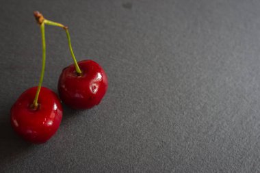 Olgun kirazlar kara tahtada. Masada sulu kirazlar var. Kiraz meyveleri. Yaz hasadı konsepti. Taze meyve. Vitamin ve içecek konsepti. Sağlıklı çiğ tatlı. Tatlı diyet. 
