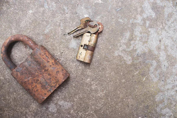 Old rusty keys, lock and antique padlock. Vintage door padlock with key. Antique key on weathered background. Security and safety concept. Aged iron key and padlock. House protection concept.