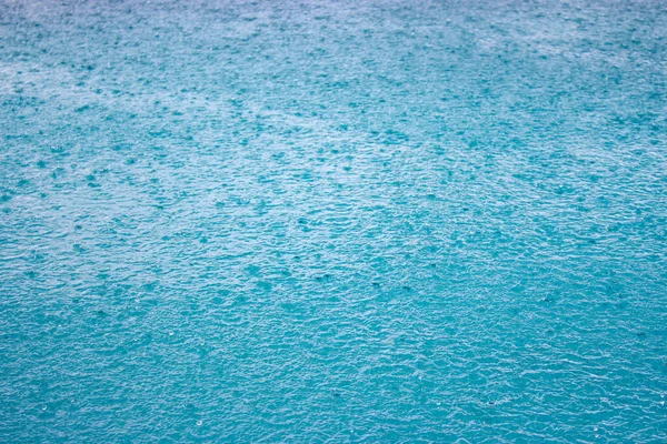 Blauer Wasserhintergrund Mit Regentropfen Tropfen Fallen Auf Die Wasseroberfläche Wellen — Stockfoto