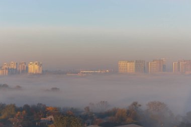 Şehrin üzerinde yumuşak bir gün doğumu. Sabahları gökyüzü sisle kaplanıyordu. Şehir merkezinde sabah bulanıklığı, yüksek açı manzarası. Kopya alanı olan puslu şehir manzarası. Kasabada sonbahar manzarası.