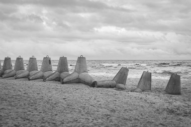 Plajda tetrapodlar, Ukrayna, siyah ve beyaz. Rus istilasına karşı bariyerli kışın deniz manzarası. Ukrayna kıyı savunması. Kumda üst üste Tetrapod. Savaş sırasında deniz kenarında. Sahil koruması olan Karadeniz manzarası.