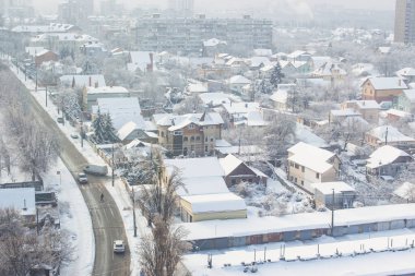 Şehirde kış mevsimi. Çatıda kar var. Kış Kyiv dönüm noktası. Soğuk kış havası. Şehir merkezinde kar yağışı. Kar ve rüzgar. Güneşli bir günde binalar ve sokaklar karla kaplı.