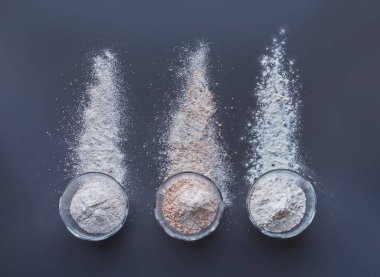 Gri bir masada ekmek pişirmede kullanılan farklı unlardan.