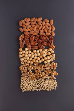 Çeşitli fındıklar, iyi bir protein kaynağı, gri masaya yerleştirilmiş.