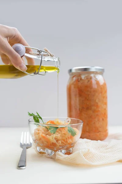 fermented food, sauerkraut or fermented cabbage in a glass jar on a light background