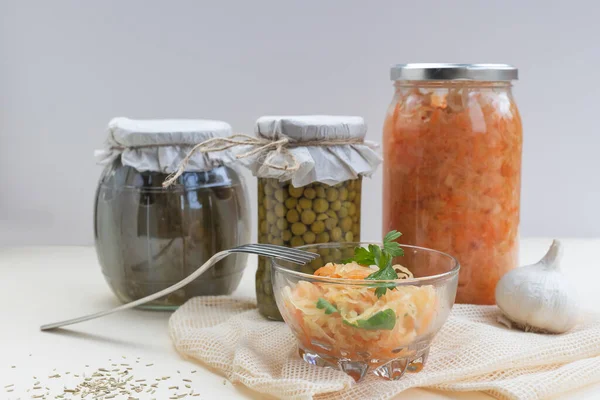 fermented food, sauerkraut or fermented cabbage, pickled cucumbers, peas on a light background