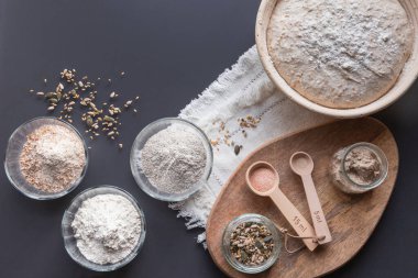 Ev yapımı ekşi hamur pişirmek için kullanılan malzemeler: çavdar, kepekli tahıl, sade buğday unu, tohum, başlangıç, tuz, maya
