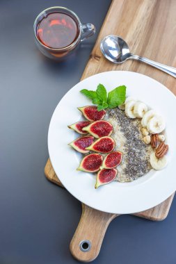 Kahvaltıda yulaf lapası, chia tohumu, taze incir ve muzlu bir kase.